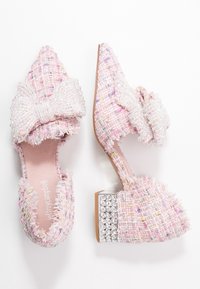 Rosa tweed-mules med en strukturerad yta, stor rosettdekoration och en tjock klack med kristalldekoration.