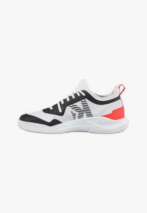 Scarpa sportiva bassa bianca con dettagli neri, tomaia in mesh, lacci, lato con motivo, linguetta rossa sul tallone e suola bianca testurizzata.