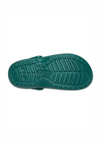 Groene rubberen zool van een schoen met een gestructureerd grippatroon, verhoogde secties en afvoergaten, voorzien van het merk "crocs" op de voetboog.