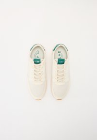 White mesh sneakers with cream-colored accents, lace closure, and a teal tag labeled "CLAE." Rubber sole with an orange detail.