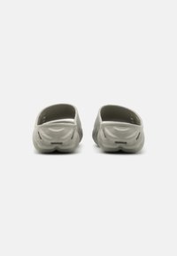 Gray slip-on clogs with a smooth, textured surface, open back, and slight arch; featuring ventilation holes and a rounded toe design.
