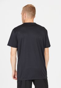 Svart t-shirt med kort ärm, tillverkad av slät tyg, något figursydd design, rund hals och sömdetaljer längs ärmarna och nederkanten.