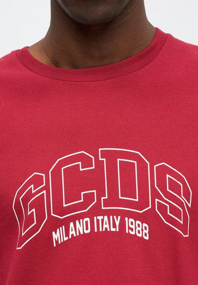 Crvena pamučna majica s okruglim izrezom, teksturiranom tkaninom i odvažnim bijelim grafičkim natpisom "GCDS MILANO ITALY 1988."