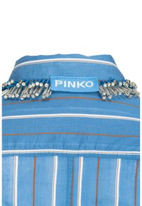 Camicia a righe blu con un collare decorato da perline scintillanti e un'etichetta blu con il marchio "PINKO". La texture sembra leggera e liscia.