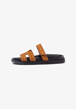 Infradito in suede marrone con due fasce ampie dotate di borchie, suola nera imbottita e design piatto per un look casual.