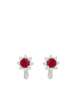 Orecchini in argento con gemme rosse rotonde centrali circondate da piccole pietre trasparenti in un design a forma di fiore su sfondo bianco.