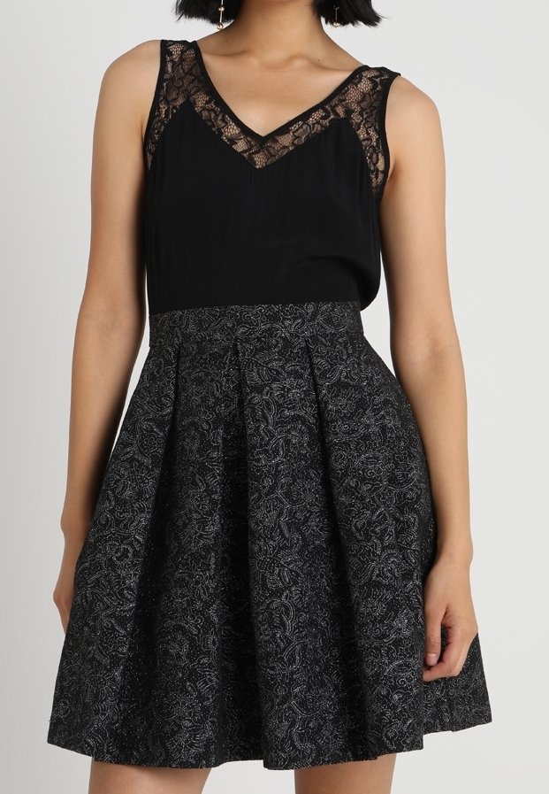 Robe noire avec un corsage ajusté agrémenté de dentelle et une jupe évasée, détaillée d'un motif floral et d'un tissu texturé.