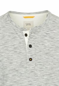 Chemise à manches courtes rayée en blanc et noir, avec un col rond, une patte de boutonnage à trois boutons et une petite poche avant. En mélange de coton.