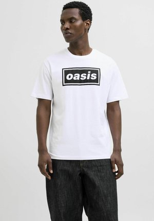 White cotton T-shirt featuring a black rectangular graphic that displays the word "oasis," paired with dark denim jeans.