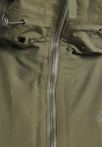 Olive green jacket featuring a full zipper, drawstring hood, and metal hardware accents. The fabric appears smooth with subtle stitching details.