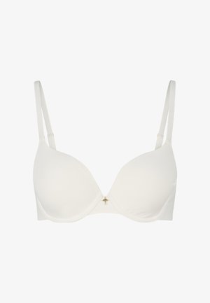 Valkoinen alusfarkku, jossa on sileät kupit, säädettävät hihnat ja pieni kultainen yksityiskohta keskellä. Valmistettu pehmeästä kankaasta.