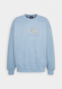Ljusblå sweatshirt i mjukt material, med rund halsringning, nedhasade axlar och en färgglad grafisk design med text fram.