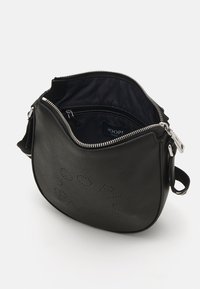 Borsa a tracolla in pelle nera con hardware silver, chiusura con zip e logo impresso. Interno rivestito in tessuto scuro e dotato di una tasca con zip.
