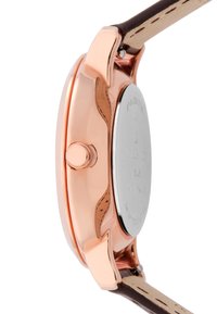 Boîtier de montre en métal rose gold avec une surface lisse, couronne unique sur le côté, et un bracelet en cuir marron clair avec des détails de couture.