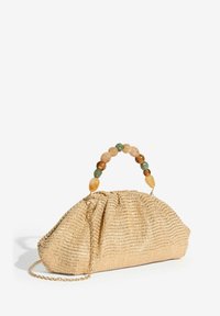 Geantă plic bej țesută cu mâner din mărgele multicolore și curea cu lanț auriu pe fundal alb.