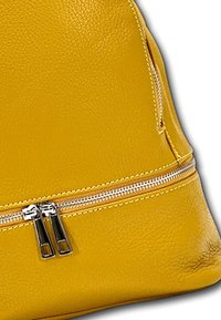 Sac à main en cuir jaune avec une surface texturée, un zip bien visible avec des détails en métal argenté, et une forme structurée.