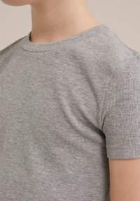 Grå randig kortärmad T-shirt med rund halsringning, som visar en mjuk, texturerad tygkvalitet och en figurnära silhuett.