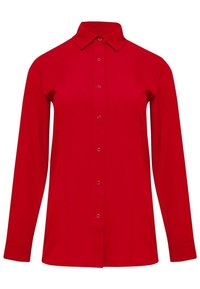 Chemise rouge à manches longues avec col pointu, texture lisse, et patte de boutonnage avant dotée de boutons ronds de couleur argentée.