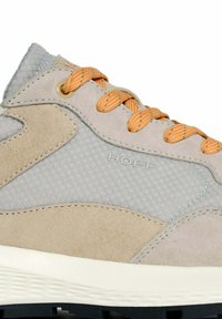 Scarpa sportiva beige e grigia realizzata in suede e mesh, con lacci arancioni a contrasto e una suola testurizzata. Logo "HOFF" visibile.