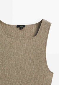 Beige ribbed tank top with a wide neckline, featuring a smooth texture and stitched trim, tagged with brand information inside.