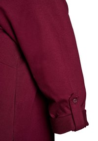 Bordeaux lange mouw shirt met een gladde textuur, met een knoop op de manchetten en een subtiel, gestructureerd ontwerp.