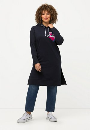 Abito con cappuccio navy a maniche lunghe, con cordini bianchi e grafica colorata "ALWA". Indossato sopra jeans cropped azzurri chiari e sneakers bianche.