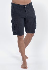 Pantaloni cargo in lino neri con tasche laterali, chiusura a bottone e vestibilità rilassata. Presentano un orlo che termina appena sopra il ginocchio.