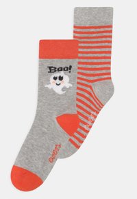 Szürke zoknik narancssárga részletekkel; az egyik szellemet és "Boo!" grafikát ábrázol, míg a másik vízszintes narancssárga csíkokkal díszített. Puha, kötött anyag.