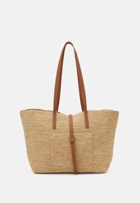 Ompelukassi, joka on valmistettu punotusta oljesta ja on beige väriltään. Kassissa on ruskeat nahkahihnat ja keskellä nahkainen yksityiskohta, jossa on kullanvärinen koriste.