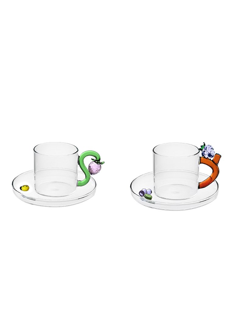 Dwa przejrzyste szklane kubki z kolorowymi uchwytami: jeden zielony w kształcie węża z fioletowym akcentem owocu, drugi pomarańczowy z kwiatowymi detalami.