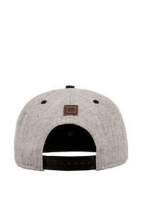 Grå baseballcaps med en teksturert stoff, svart justerbar snapback, og et brunt logo-patch på baksiden.