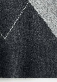 Tessuto di lana lavorato a maglia in diverse tonalità di grigio scuro e grigio chiaro, caratterizzato da un motivo diagonale e una superficie morbida e texturizzata.