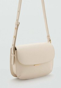 Borsa a tracolla in pelle beige con chiusura a patta, tracolla regolabile con fibbia dorata e minimo accento dorato sul davanti.