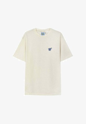 Beżowy t-shirt z krótkim rękawem i okrągłym dekoltem, z małym niebieskim logo przedstawiającym winogrona oraz tekst na lewej piersi.