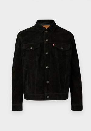 Melna zamšā jaka ar apkakles kaklu, četriem priekšējiem kabatām un kontrastējošām šuvēm. Pieder pogu aizdares un klasiskā dizaina.