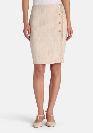 Beige tweed rok met een aansluitend ontwerp, heeft een sluiting met knopen aan de zijkant en een gestikte accentlijn langs de rand. Gecombineerd met neutrale schoenen.