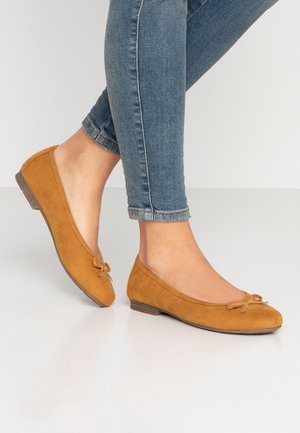 Tan suede ballet flats with a rounded toe and a decorative bow at the vamp. Features a low, stacked heel for comfort.
