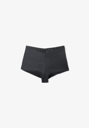 High-waisted black shorts featuring a smooth texture, side zipper, and gold studs along the waistband for detail.