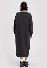 Lang, oversized, donkergrijze sweatshirtjurk met een ronde halslijn en verlaagde schouders. Gemaakt van zachte stof, met ribgebreide manchetten en zoom.