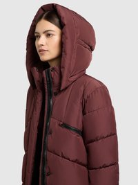 Burgundia tooni sulejope suure kapuutsiga, polsterdatud tekstuuri, esiosal lukuga ja lukuga rinnataskuga. Omaduseks läikiv must lukk.