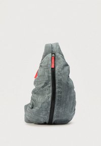 Grå stoffveske med et teksturert mønster, med en svart glidelås og en rød trekkflik. Teksten "SUCCESSFUL LIVING" trykt på siden.