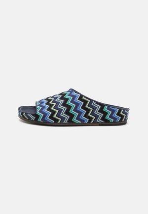 Sandales à enfiler bleu et noir avec un motif en zigzag vert et bleu clair. Tige douce, design ouvert à l'avant et semelle plate.
