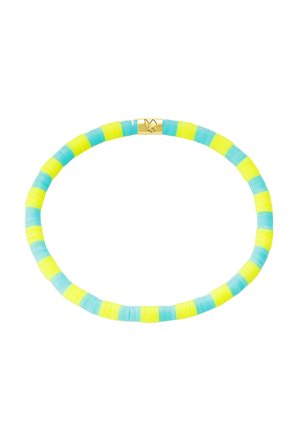 Bracelet élastique avec des perles plates rondes alternées jaunes et bleu clair, avec une petite fermeture en or gravée d'une colombe.