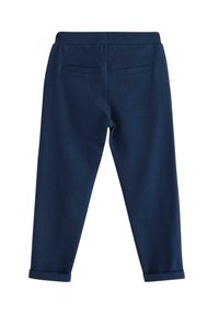 Marineblauwe slimfit broek met elastische tailleband, twee achterzakken met stiknaad en opgerolde mouwen, getoond vanuit de achterkant op een witte achtergrond.