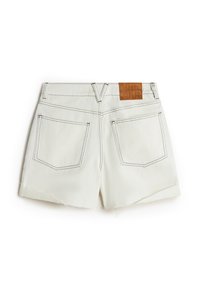 Shorts en denim blanc avec un ourlet légèrement effiloché, deux poches arrière, des coutures contrastées et une étiquette en cuir texturé marron à la taille.