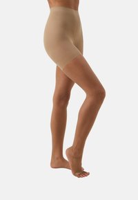 Beige control shorts with a smooth texture, mid-thigh length, and no foot coverage, designed for a snug fit and comfort.