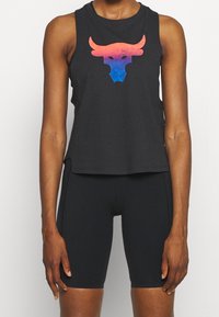 Svart ärmlös linne med en färgstark tjurlogga (rosa till blå gradient). Kombineras med svarta, figurnära cykelshorts. Mjuk tygtextur.