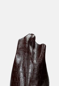 Bruine, gestructureerde leren handtas met een kenmerkend krokodillenpatroon, met een gladde afwerking en een binnenritssluiting.