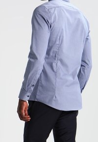 Blauw patroonhemd met een slim-fit pasvorm, voorzien van een button-down kraag en lange mouwen, gemaakt van lichtgewicht stof met een gladde textuur.