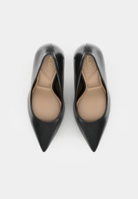 Décolleté neri a punta realizzati in pelle liscia con una soletta beige. L'interno presenta un motivo di design sottile per il comfort.